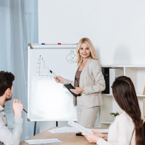 smiling mature businesswoman pointing at whiteboar 2026 01 06 00 43 55 utc